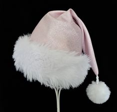 "Pastel pink polyester fabric with metallic silver glittered sparkle accents makes up this novelty Santa hat in classic Santa hat styling. Hat is fully lined with a white cotton fabric and there is a soft and fluffy white faux fur fabric turn up brim for the trim and a white faux fur pompom dangle.  Proportions of the hat are generous and will fit most head sizes, ladies or gents.  Measurement for opening for your head is 24-25\" circumference and the length is 20\". Check measurements to make s Pink Winter Party Hats, White Mini Hats For Winter Party, Hat Styling, Pink Santa Hat, 2000s Pink, Santa Claus Costume, White Cotton Fabric, Fur Fabric, Christmas Celebration