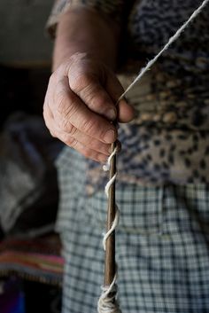 an old woman holding on to a rope with her left hand and the end of it