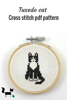 a cross stitch cat sitting in front of a black and white background with text that reads tuxedo eat cross stitch pattern