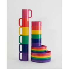 a stack of colorful cups sitting next to each other on top of a white surface