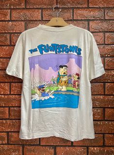 "Vintage 90s The Flintstones American Animated Cartoon Pop Art Graphic T Shirt / 90s Streetwear T Shirt Size L Condition : Good Used Size on tag : L Colour : white Brand : Xox Measurement : Armpit to armpit - 20.5\" Length - 25\" Material : Cotton Made In: Thailand THE SHIPPING (Your Choice Please read) 1. The shipping cost is USD 20 via Malaysian Registered Postage With Tracking Number. It will take 2-4 weeks or more for delivery, depends on your custom checking. 2. Add USD 10 for speedy delive Cheap Pop Culture T-shirt With Character Print, Vintage Cartoon Shirt, Cartoon Pop Art, Cartoon Pop, Teen Swag, Teen Swag Outfits, The Flintstones, Streetwear T Shirt, Cartoon T Shirt