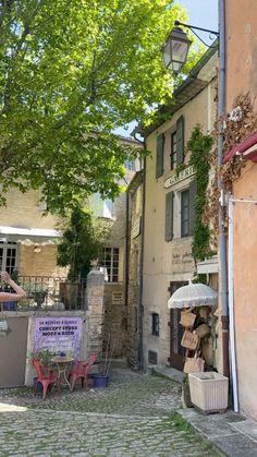 an alleyway with tables, chairs and umbrellas