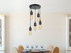 a dining room table and chairs with light bulbs hanging from the ceiling