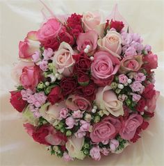 a bouquet of pink and red flowers on a white background