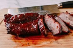 sliced meat on a cutting board next to a knife