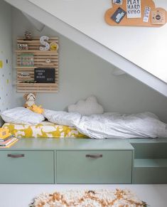 a bed sitting under a stair case next to a wall mounted clock and book shelf