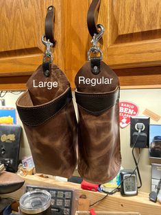 two brown boots hanging from hooks in front of a kitchen counter with other items on it