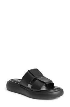 Oversized leather straps kick off a modern slide sandal set atop lightweight padding and a chunky contrast sole. 1 1/2" platform Flat sole Cushioned footbed Leather upper and lining/synthetic sole Imported Modern Platform Slippers With Leather Footbed For Beach, Modern Black Platform Footbed Sandals, Modern Black Slide Footbed Sandals, Modern Synthetic Slide Footbed Sandals, Platform Flats, Monochrome Design, Perfume Gift Sets, Leather Slide Sandals, Chunky Platform