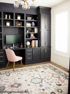 a living room with black bookcases and a pink chair