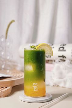 a green and yellow drink sitting on top of a table