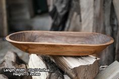 a wooden bowl sitting on top of a pile of wood