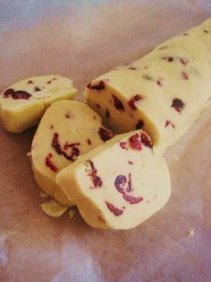 slices of cheese with berries on them sitting on a piece of parchment paper