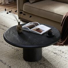 a coffee table with a book and vase on it