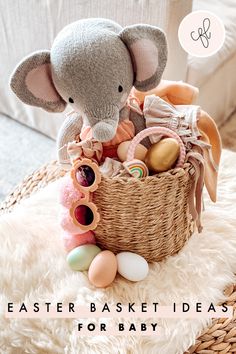 an elephant stuffed animal sitting in a basket filled with baby items on a white rug