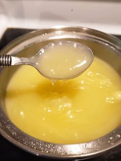 a spoon full of liquid sitting on top of a stove