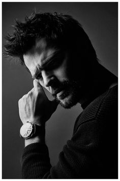 a black and white photo of a man wearing a watch