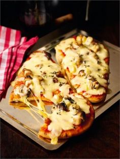 several slices of pizza with cheese and toppings on a tray