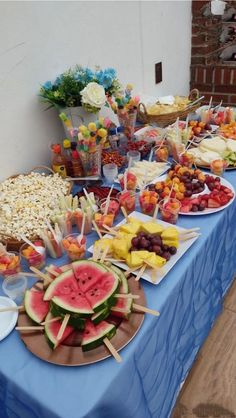 a blue table topped with watermelon slices and other foods on top of it