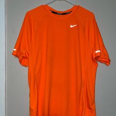 Men’s Orange Running Shirt With Nike And Side Reflector Size: Large Nwot Sporty Orange Short Sleeve Shirt, Nike Orange Short Sleeve Tops, T Shirt Nike Orange, Orange Crew Neck T-shirt With Moisture-wicking, Nike Running Shirt, Nike Yellow Short Sleeve T-shirt, Nike Moisture-wicking Sportswear T-shirt, Cheap Orange Men's T-shirt, Running Shirts