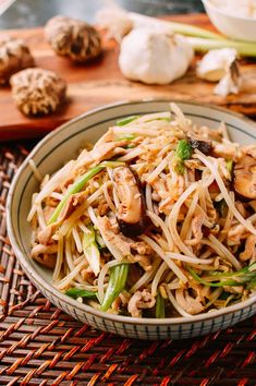 a close up of a bowl of food on a table with mushrooms and broccoli