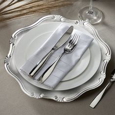 a white plate topped with silverware on top of a table