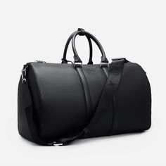 Explore elegance and utility in our Saffiano Leather Duffle Bag. Featuring intricate silver detailing and the GC logo, it makes a statement of sophistication. With two inside pockets and a removable shoulder strap, it's designed for versatility and functionality. Elevate your journey with this exquisite duffle bag. SIZE W 50 x H 29 x D 24 cm Luxury Duffel Bag, Black Leather Duffle Bag, High-end Travel Shoulder Bag With Silver-tone Hardware, Luxury Travel Shoulder Bag, Luxury Shoulder Bag With Silver-tone Hardware For Travel, Luxury Business Travel Bag With Adjustable Strap, Luxury Travel Shoulder Bag With Silver-tone Hardware, Luxury Duffle Bag With Adjustable Strap For Daily Use, Luxury Travel Bag With Adjustable Strap For Business