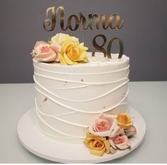 a white cake with flowers and the number 80 on top