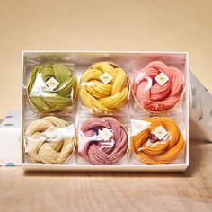 six different colors of thread in a box