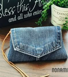 a denim purse sitting on top of a wooden table