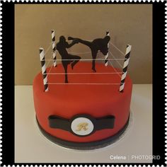 a cake with two people on top of it and some black and white sticks in the middle