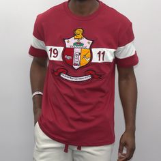 Experience the true essence of style with this Crimson T-Shirt from Kappa Alpha Psi Shield. Immerse yourself into a world of elegance and sophistication with its vibrant crimson color. This T-Shirt is a must-have for every stylish man out there as it adds an extra edge to your wardrobe. The Kappa Alpha Psi Shield logo on the shirt showcases your inner strength and vigor. Wear it comfortably to any occasion and let your personality speak for itself. Fast Shipping & Processing: 1-2 days to process Red Crew Neck T-shirt With Embroidered Logo, College Crew Neck T-shirt With Embroidered Logo, Graphic Tee With Embroidered Graphics For College, Short Sleeve Tops With Embroidered Graphics For College, Collegiate Embroidered Crew Neck T-shirts, Collegiate Cotton T-shirt With Embroidered Graphics, Fitted Crew Neck Top With Embroidered Logo, Varsity Cotton T-shirt With Embroidered Graphics, Collegiate Crew Neck Top With Embroidered Graphics