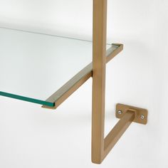 a glass shelf with a metal hook on it