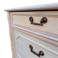 a white dresser with brass handles and knobs on it's drawers, against a white background