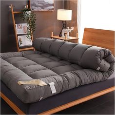 a large gray futon couch sitting on top of a wooden floor next to a lamp