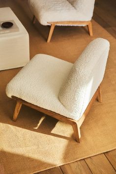 a chair and ottoman in a room with wood flooring next to a white box