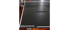 an advertisement for a ping pong table with a cat sitting on the floor next to it