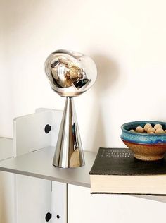 a bowl with nuts in it sitting on top of a table next to a book