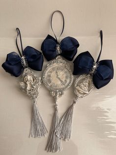 four pieces of silver and blue fabric with flowers on the top, one piece has a clock in the middle