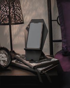 a cell phone sitting on top of a table next to a lamp and other items