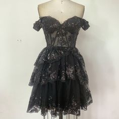 This Black Mini Dress Combines Elegance And Sensuality With Its Layered Skirt And Sheer Sequin Embroidery Design. The Shimmering Sequins Catch The Light, Creating A Stunning Visual Effect. The Tiered Skirt Adds Dimension And Movement, Making This Dress Perfect For Evening Events, Parties, Or Any Special Occasion. You’ll Stand Out In Any Crowd Wearing This Unique Piece. If You Have Any Special Requests Or Need Modifications, Please Let Me Know. Glamorous Black Lace Corset Dress, Black Corset Dress With Sweetheart Neckline For Evening, Gothic Knee-length Party Mini Dress, Black Evening Party Corset Dress, Gothic Knee-length Mini Dress For Party, Black Evening Corset Dress For Party, Black Embellished Corset Dress For Prom, Black Fitted Bodice Corset Dress For Gala, Black Corset Dress For Evening Party