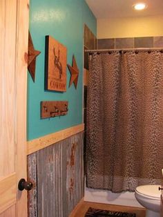 a bathroom with blue walls and leopard print shower curtain next to a toilet in the corner