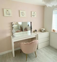 a pink chair sitting in front of a white desk with a mirror on top of it