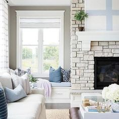 a living room filled with furniture and a fire place in front of a brick fireplace