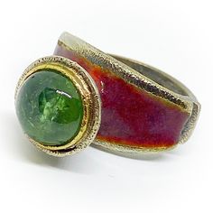 "Exclusive oxidised Sterling silver and 18K Gold ring (bezel) with a beautiful 10 mm green round Tourmaline. High quality handmade 18K Gold and oxidised Sterling silver ring. Reddish Enamel. Ring size: USA: 6 , DE: 52 (16,5 mm). ESP: 12, UK: M, FR: 52, IT: 12. If it's not size required, we can make an order custom ring for you. Delivery time a week plus shipment. If you need more information about the dimensions or more images to improve the idea of how it is or how it can be, do not hesitate to Green Enamel Ring For Anniversary, Unique Green Enamel Ring For Anniversary, Unique Green Enamel Anniversary Ring, Green Rings With Patina, Unique Emerald Ring With Bezel Setting, Unique Round Emerald Ring With Bezel Setting, Hand Forged Green Emerald Ring As Gift, Hand Forged Green Emerald Ring Gift, Unique Green Ring With Bezel Setting