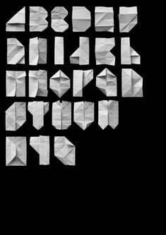 the letters and numbers are made out of white origami pieces on a black background