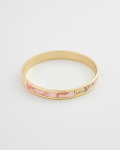 Key Features:    Nostalgic Summer Design: This gold bangle embodies the tranquility of a seaside day, adding a whimsical touch to any outfit.   High-Quality Craftsmanship: Made from 14ct gold-plated brass with an acrylic printed design in Lotus Pink for a contemporary and chic look.   Perfect Gift: Comes in a gift box with a cotton pouch, making it an ideal present for any occasion.   Dimensions:   Diameter: 2.64 inches (67 mm)  Width: 0.35 inches (9 mm)   Materials:   14ct gold-plated brass  Ac Little Gifts For Friends, Nostalgic Summer, Xoxo Jewelry, Preppy Jewelry, Cotton Pouch, Brass Bangle, Gold Plated Bangles, Jewelry Accessories Ideas, Classy Jewelry