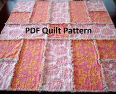 a pink and orange quilt with fringes on the bottom, sitting on top of a table