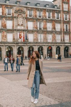 a woman standing in front of a large building