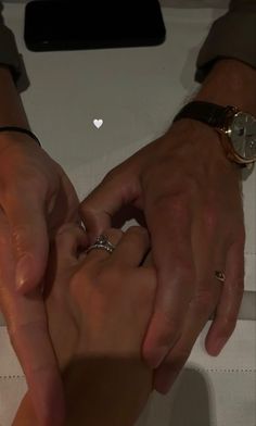 two people holding hands over each other