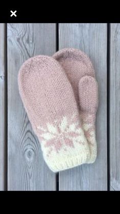 a pink mitten sitting on top of a wooden table next to a white wall